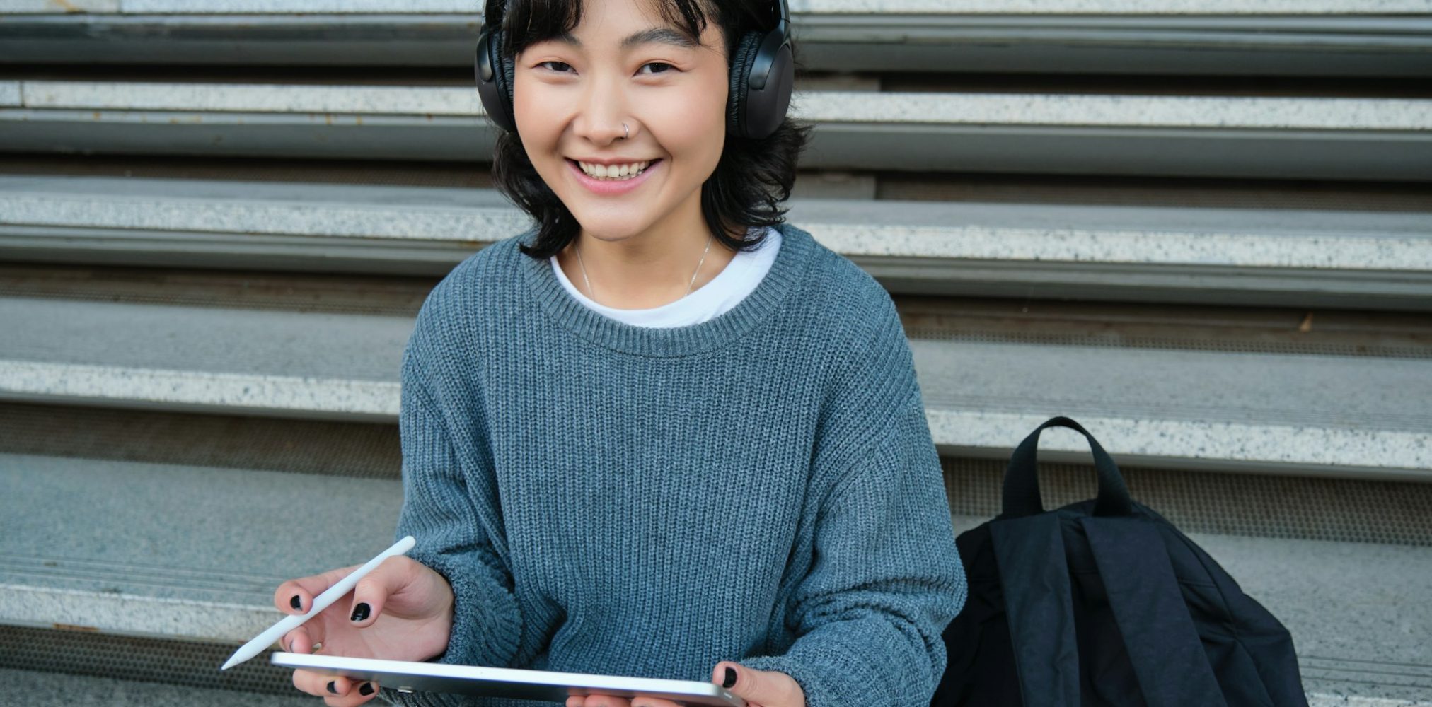 young-asian-girl-student-in-headphones-works-on-remote-digital-artist-drawing-on-tablet-with.jpg